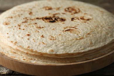 Photo of Stack of tasty homemade tortillas on table, closeup
