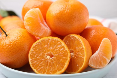 Photo of Plate of fresh juicy tangerines on white table, closeup