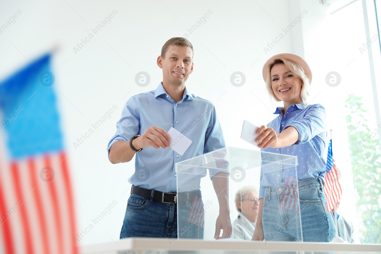 Photo of People putting ballot papers into box at polling station