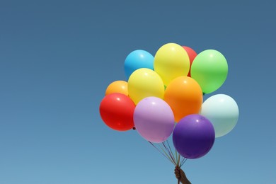 Photo of Woman with bunch of colorful balloons against blue sky. Space for text