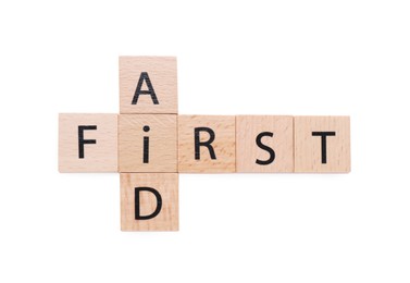 Words First Aid made of wooden cubes isolated on white, top view