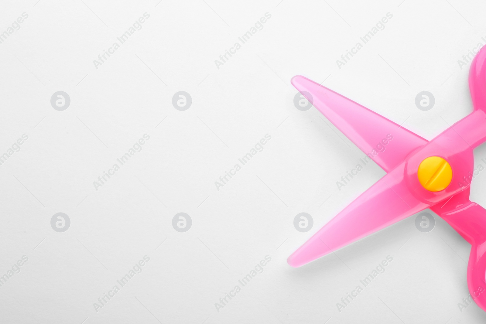 Photo of Colorful plastic scissors on white background. School stationery