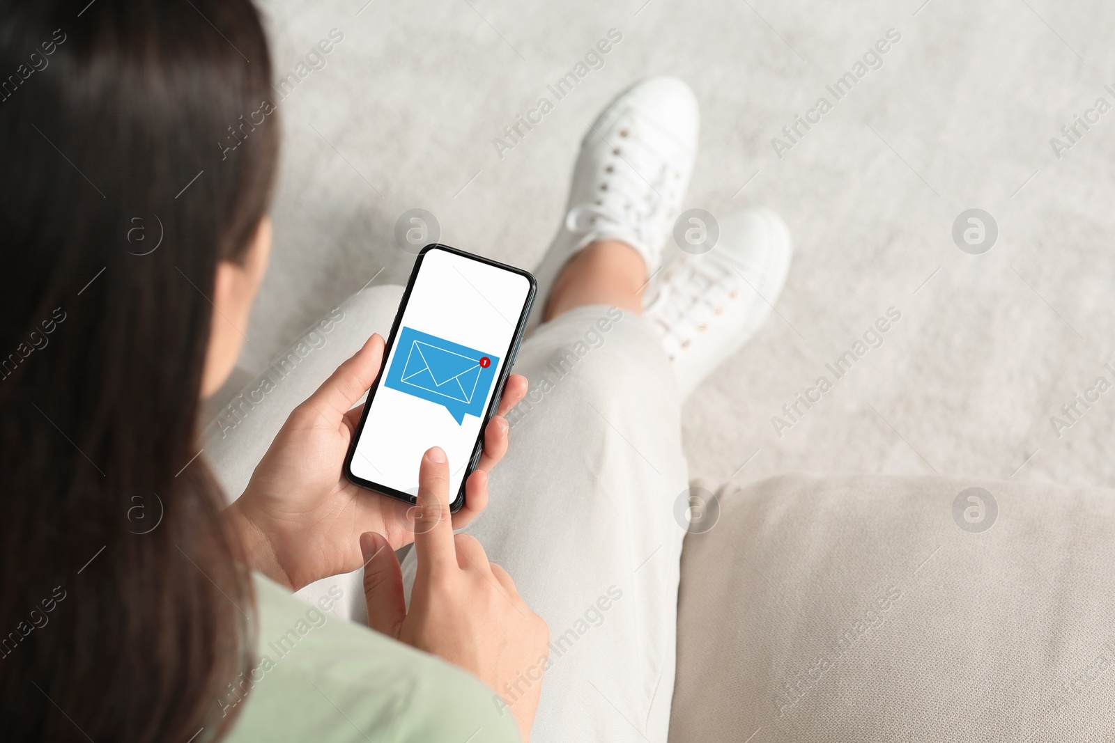 Image of Woman checking new message on mobile phone indoors, closeup