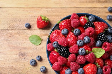 Photo of Different fresh ripe berries on wooden table, flat lay. Space for text