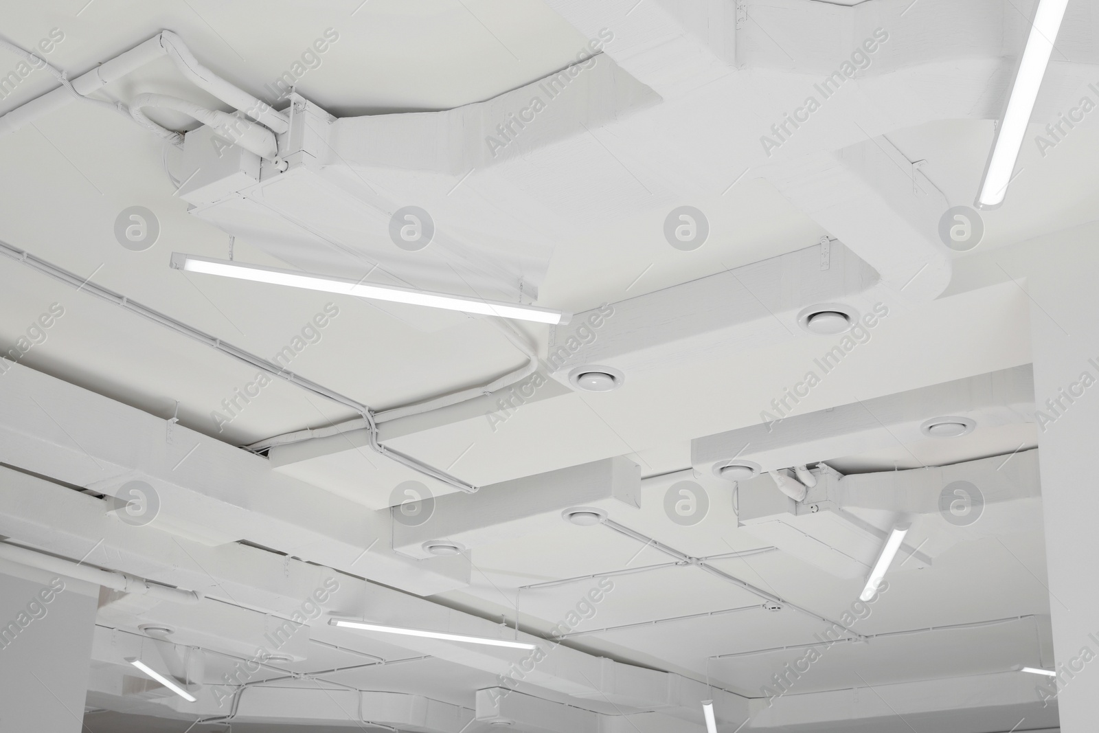 Photo of White ceiling with modern lighting in room, low angle view