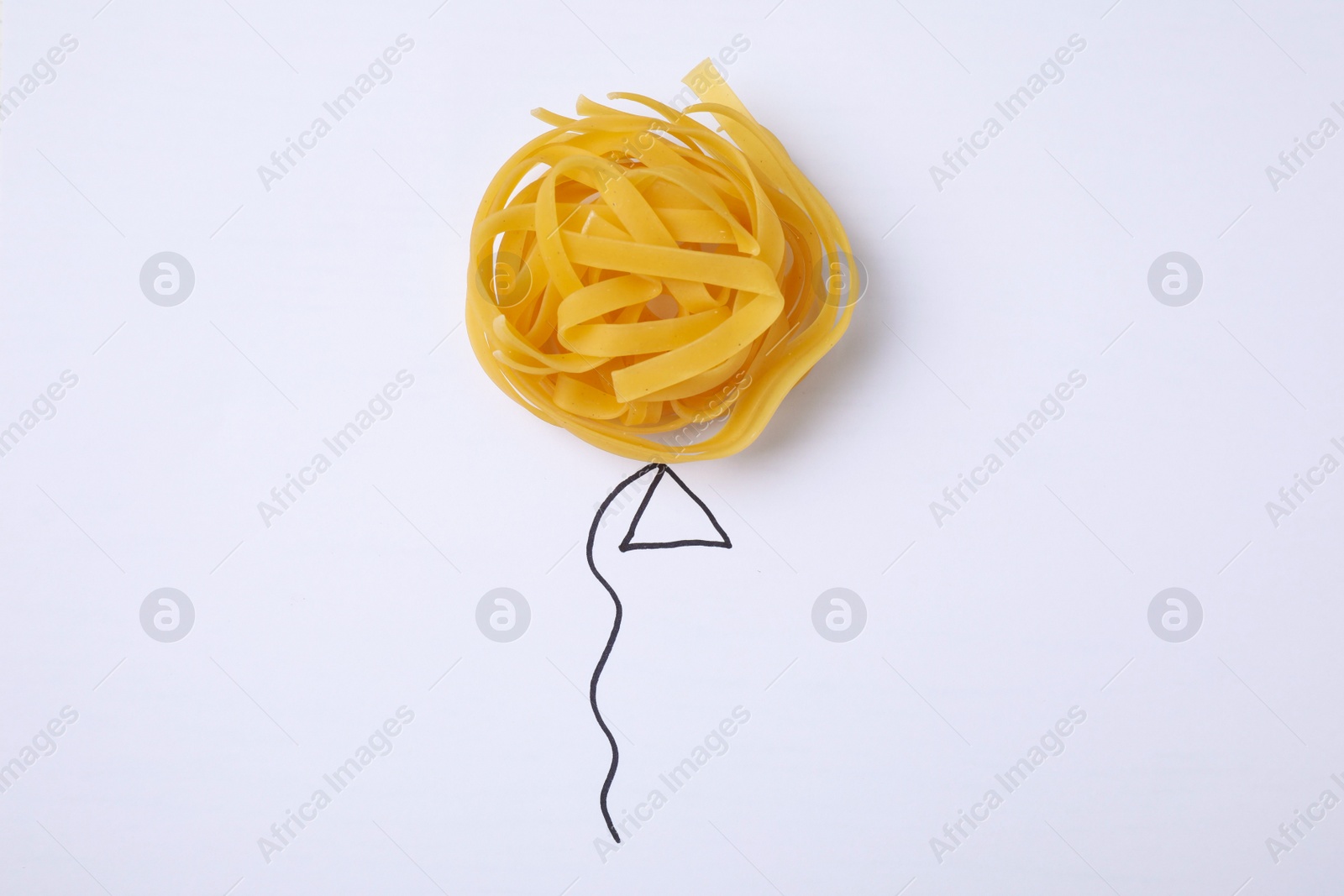 Photo of Balloon made with tagliatelle pasta on white background, top view