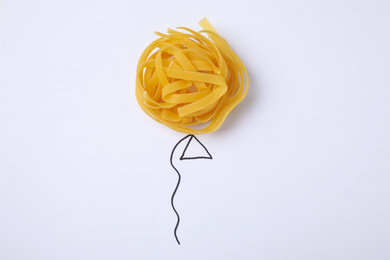Photo of Balloon made with tagliatelle pasta on white background, top view