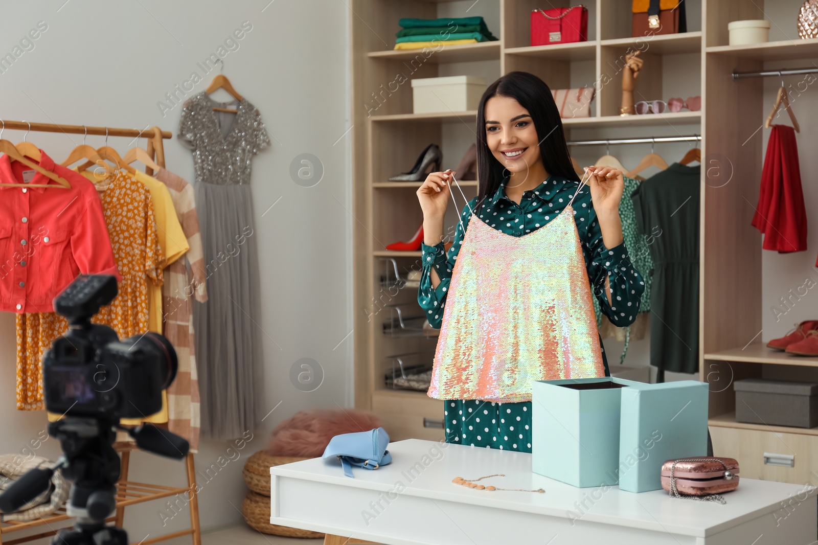 Photo of Fashion blogger recording new video at table indoors