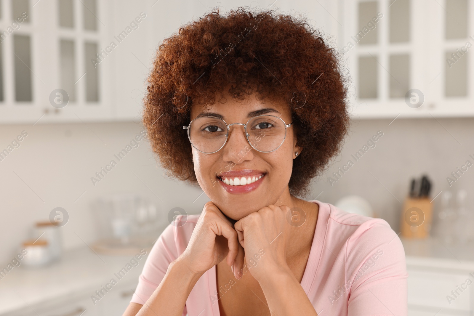 Photo of Portrait of happy young woman with eyeglasses in kitchen