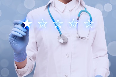 Image of Stars as symbol of quality rating. Doctor using virtual screen on light blue background, closeup