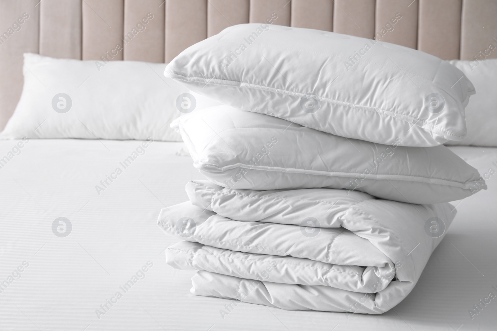 Photo of Soft folded blanket and pillows on bed indoors