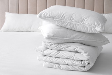 Photo of Soft folded blanket and pillows on bed indoors