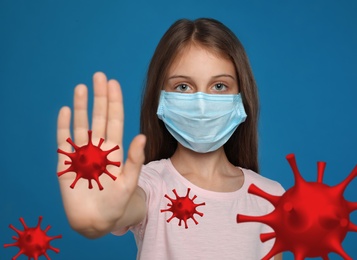 Image of Stop Covid-19 outbreak. Little girl wearing medical mask surrounded by virus on blue background