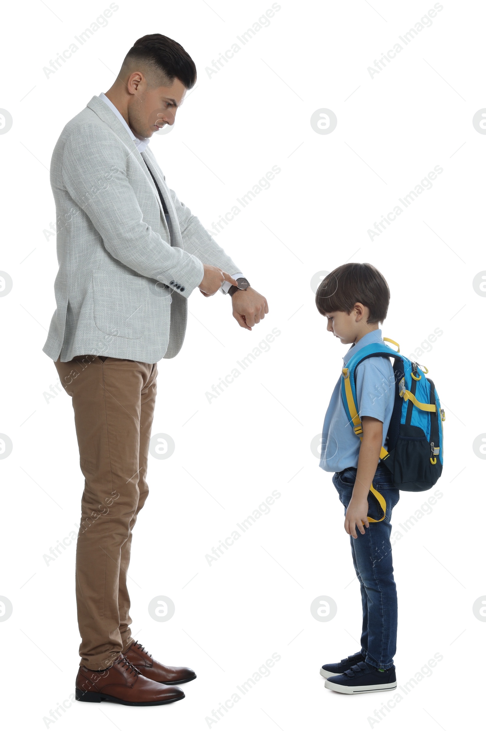 Photo of Teacher pointing on wrist watch while scolding pupil for being late against white background