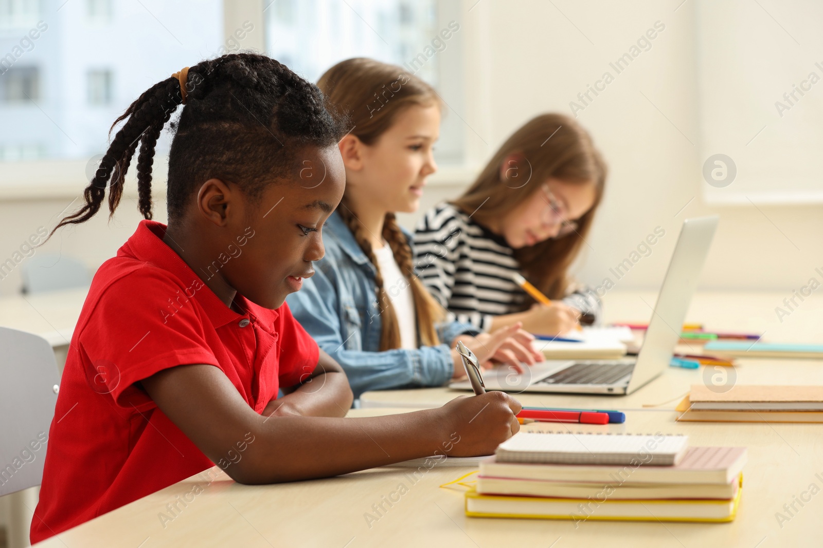 Photo of Cute children studying in classroom at school