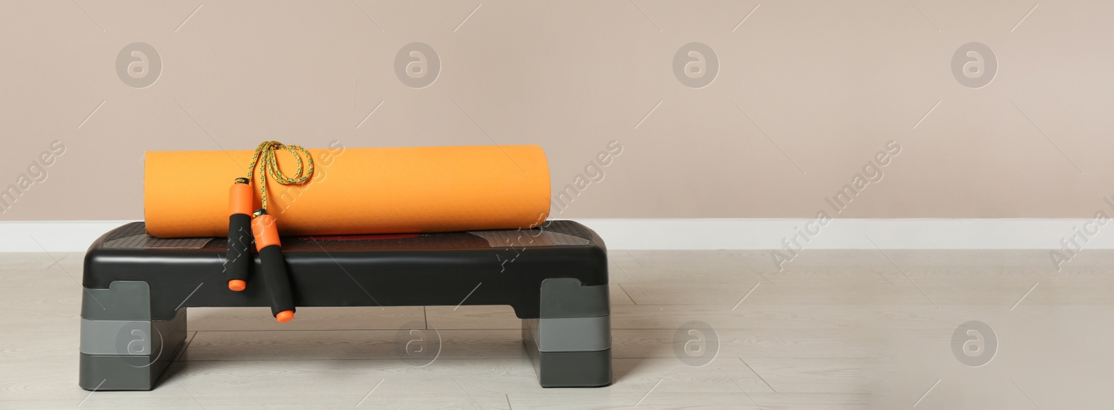 Image of Step platform, mat and jump rope indoors, space for text. Banner design