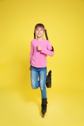 Photo of Girl with inline roller skates on color background