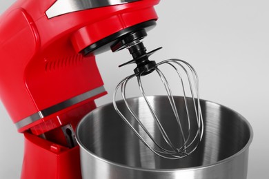 Photo of Modern red stand mixer on light gray background, closeup