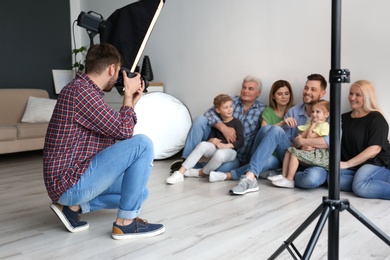 Professional photographer taking photo of family in studio