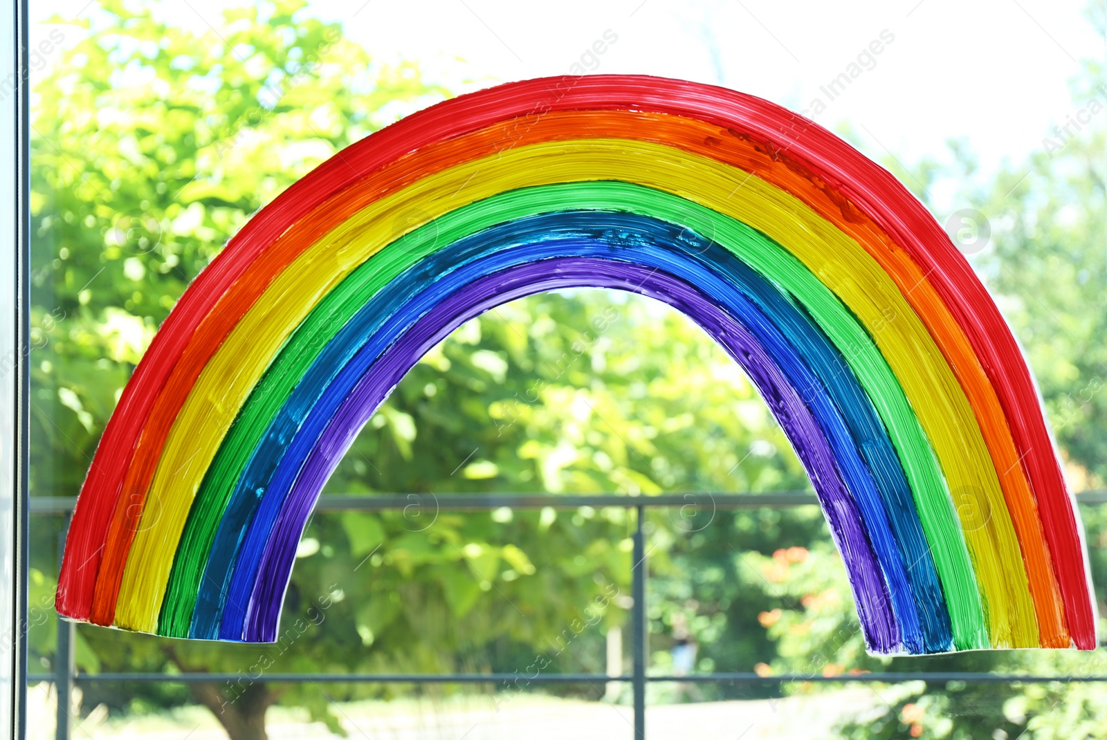 Photo of Painting of rainbow on window indoors. Stay at home concept