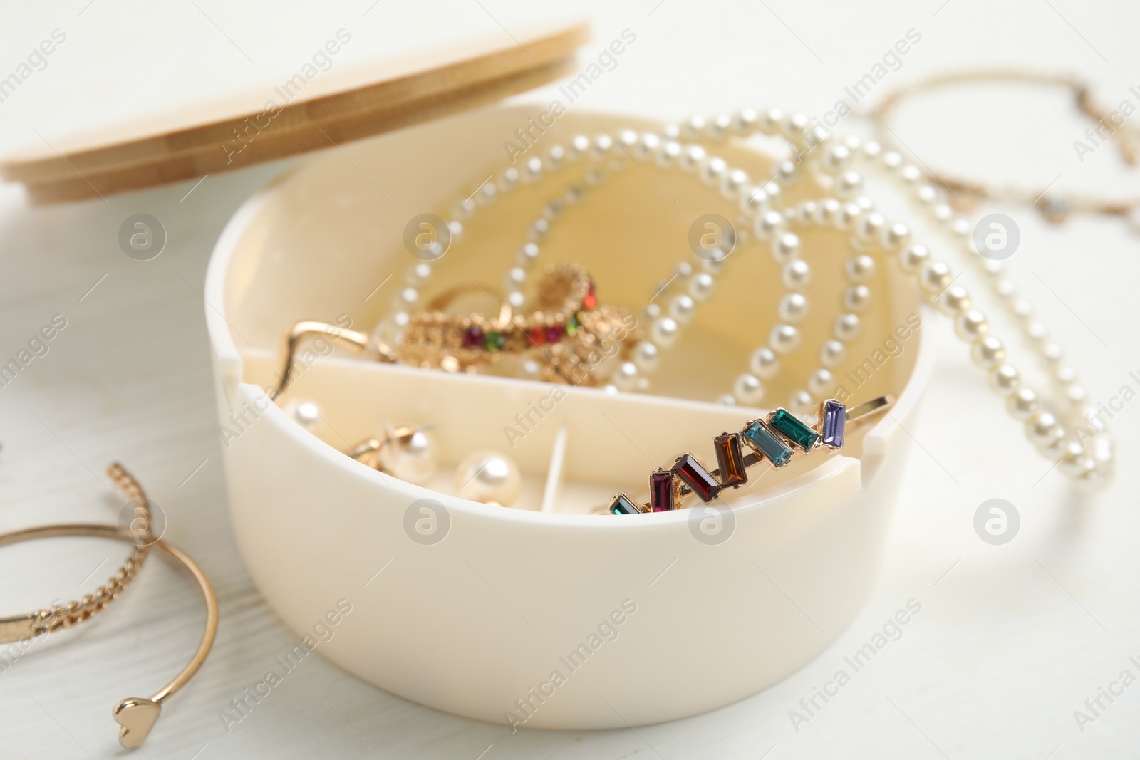 Photo of Jewelry box with stylish bijouterie on white wooden table