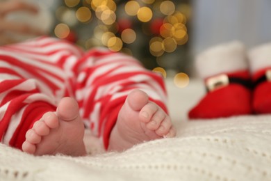 Photo of Cute little baby on blanket in room decorated for Christmas, closeup