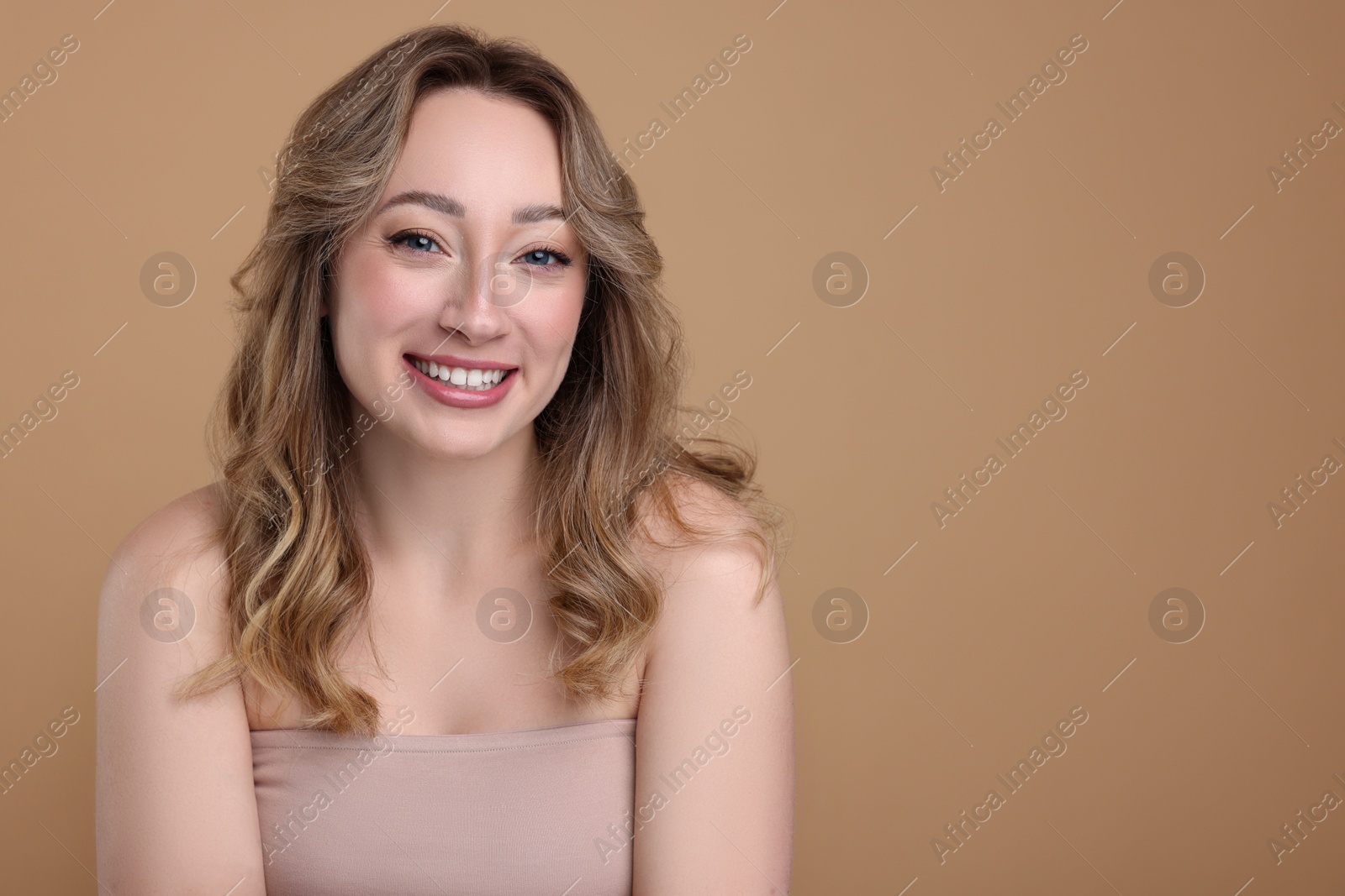Photo of Portrait of smiling woman on beige background. Space for text