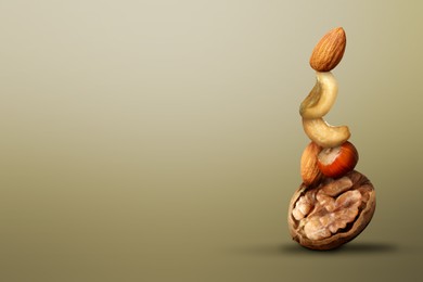 Stacked different nuts on light brown gradient background, space for text