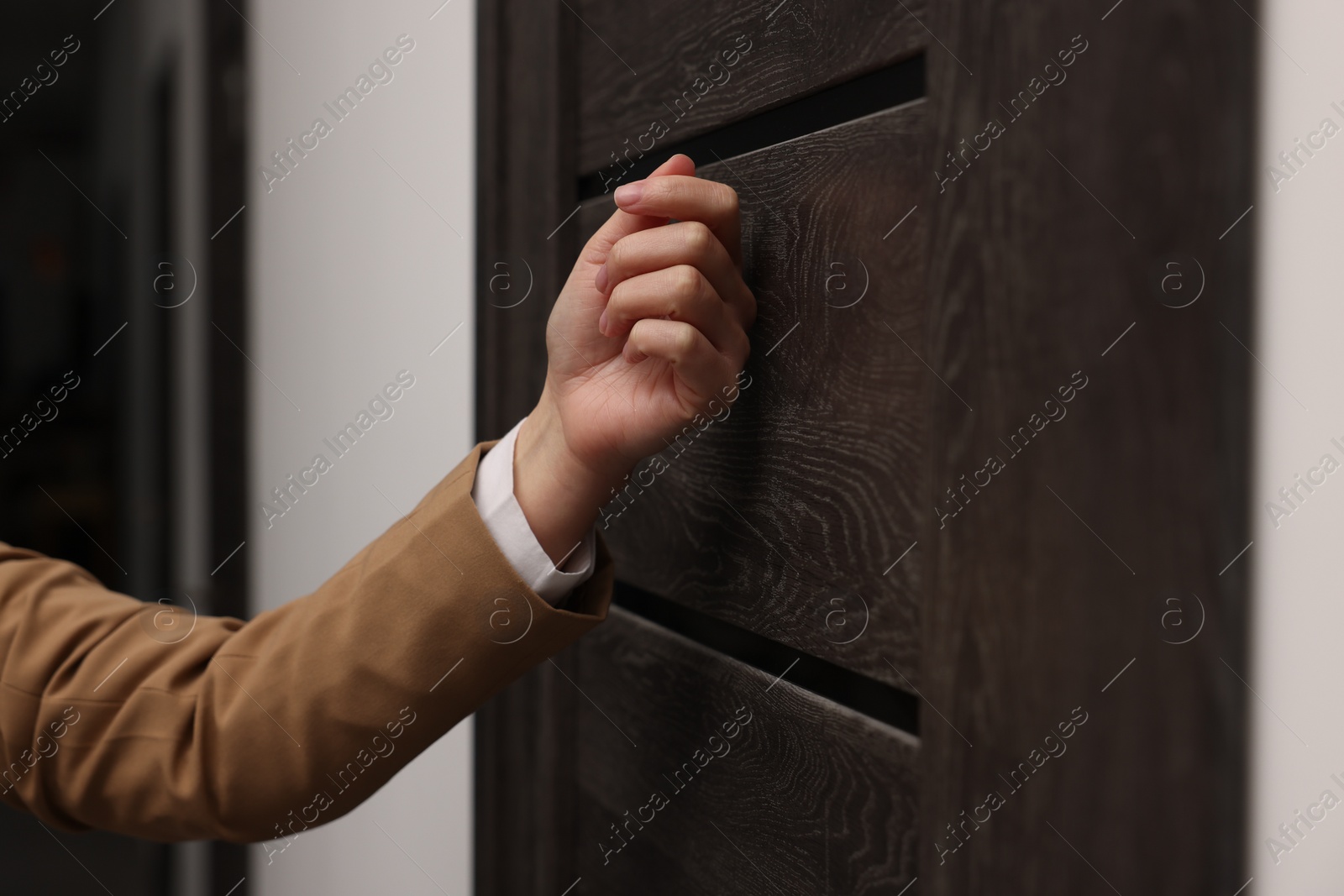 Photo of Collector knocking on door indoors, closeup view