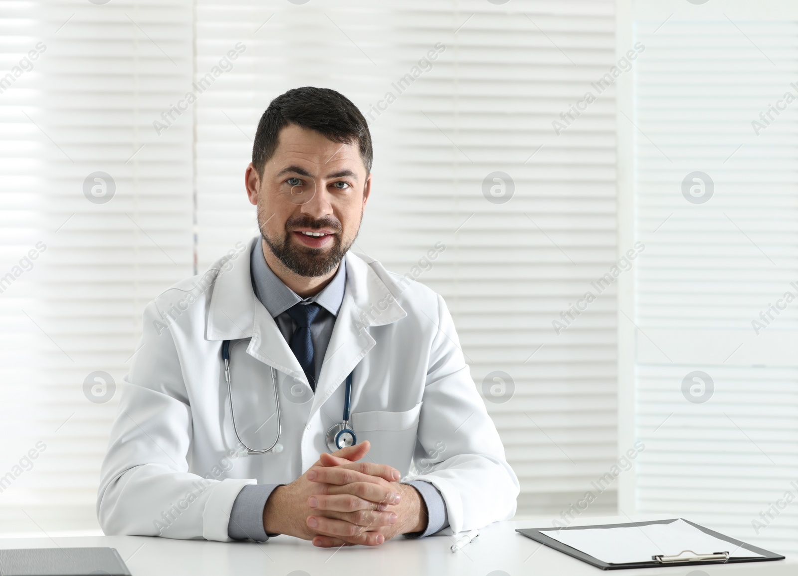 Photo of Portrait of male doctor in white coat at workplace