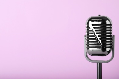 Photo of Retro microphone on color background, space for text