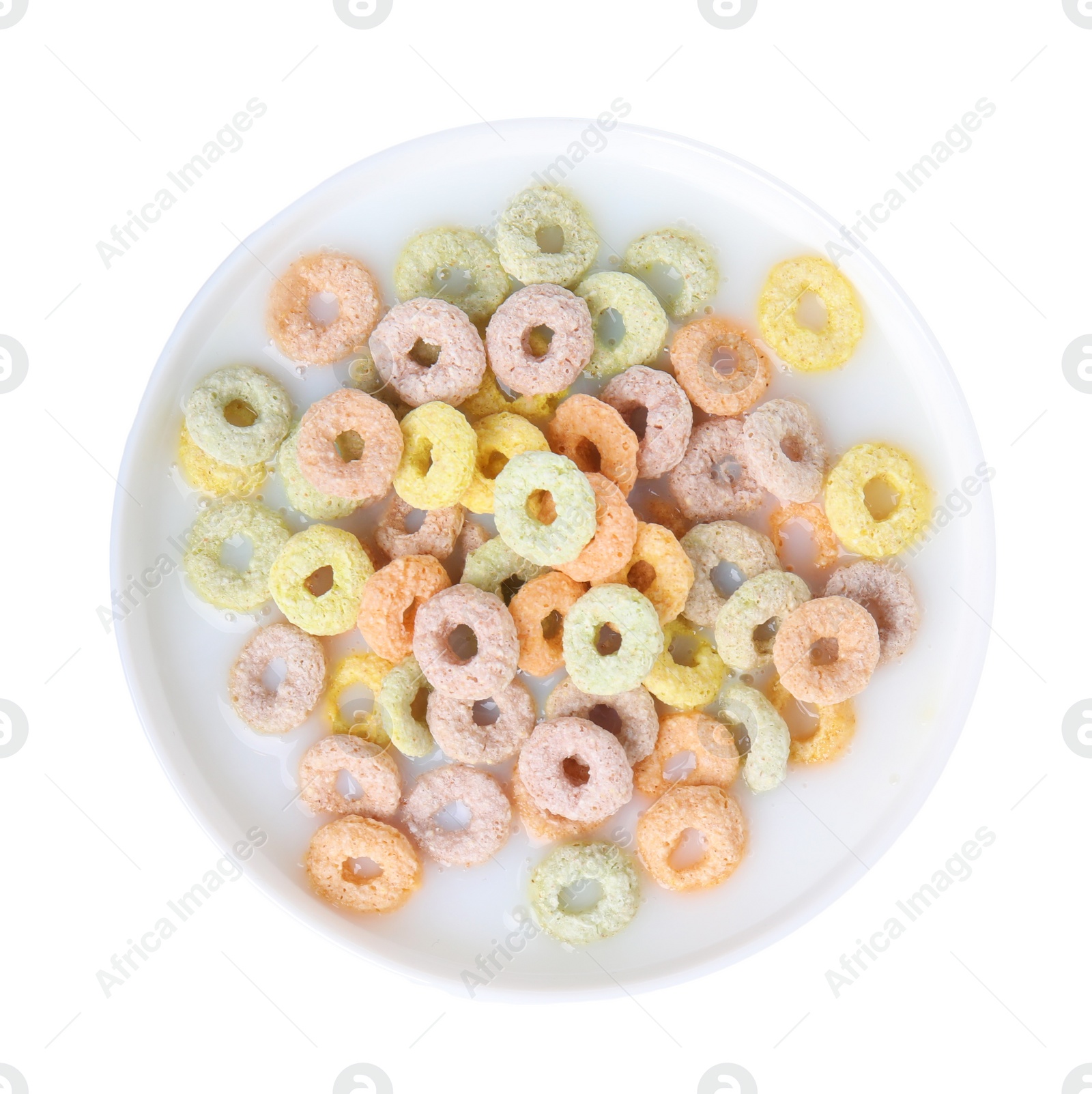 Photo of Tasty colorful cereal rings and milk in bowl isolated on white, top view