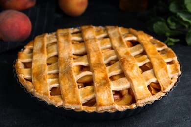 Photo of Delicious fresh peach pie on grey table, closeup