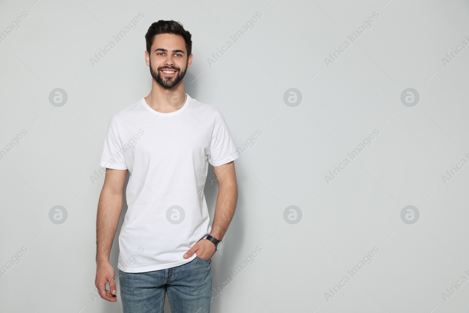 Photo of Young man in t-shirt on light background. Mock up for design