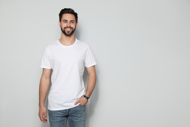 Young man in t-shirt on light background. Mock up for design