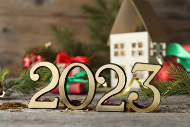 Photo of Number 2023 and festive decor on wooden table. Happy New Year
