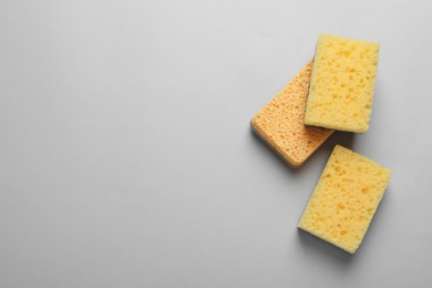 New sponges on light grey background, flat lay. Space for text