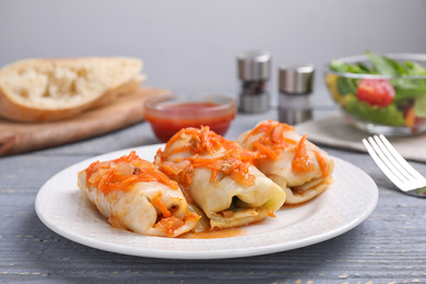 Photo of Delicious cabbage rolls served on grey wooden table, closeup