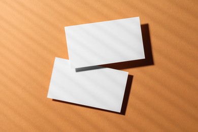 Photo of Empty business card on light brown background, top view. Mockup for design