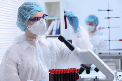 Photo of Scientist working with samples in test tubes in laboratory