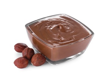 Photo of Bowl with delicious chocolate paste and hazelnuts on white background