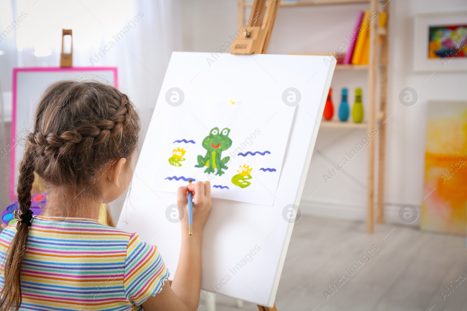 Photo of Cute little child painting during lesson in room