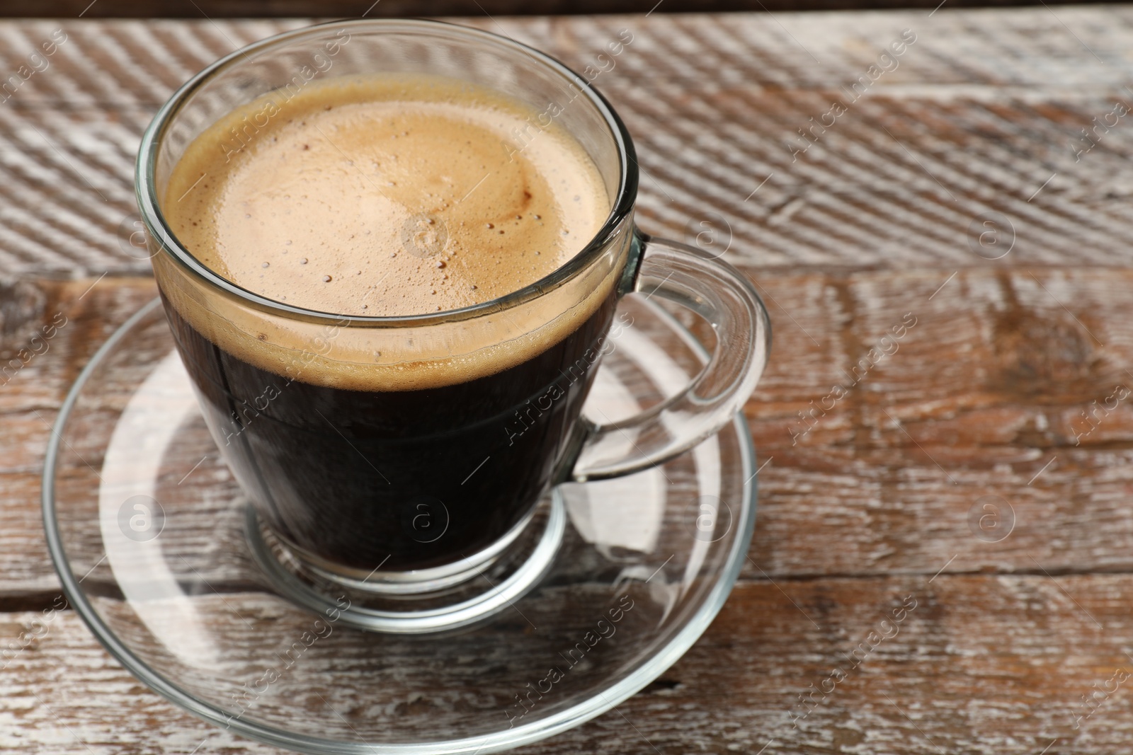 Photo of Cup of aromatic coffee on wooden table, closeup. Space for text