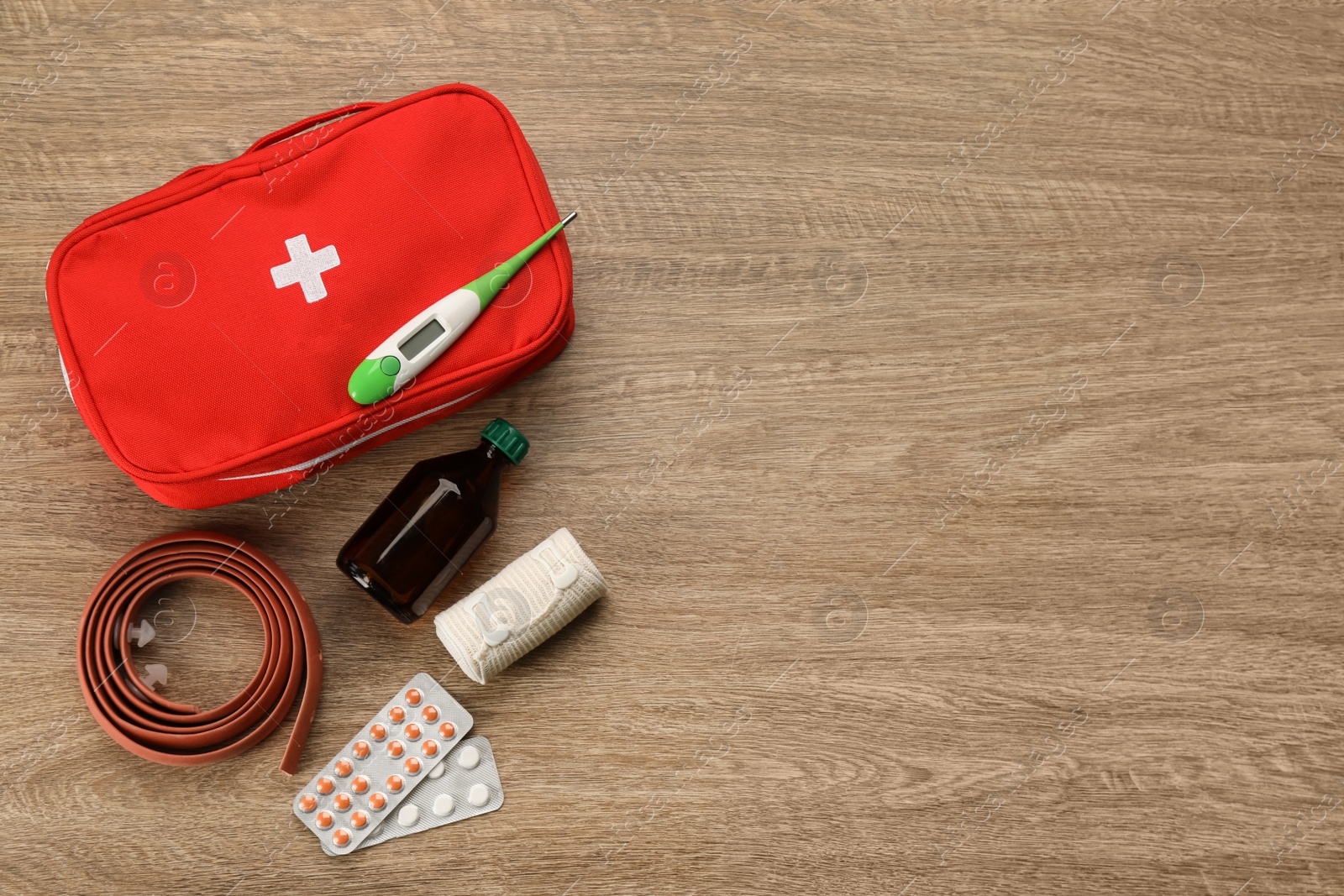 Photo of First aid kit on wooden table, flat lay. Space for text