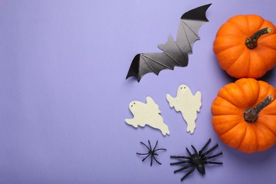 Cardboard bat, pumpkins, felt ghosts and spiders on purple background, flat lay with space for text. Halloween celebration
