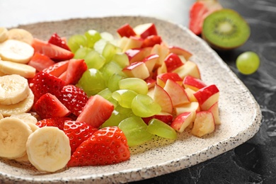 Photo of Plate with fresh cut fruits on table, closeup