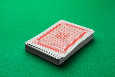 Photo of Deck of playing cards on green table, closeup. Poker game