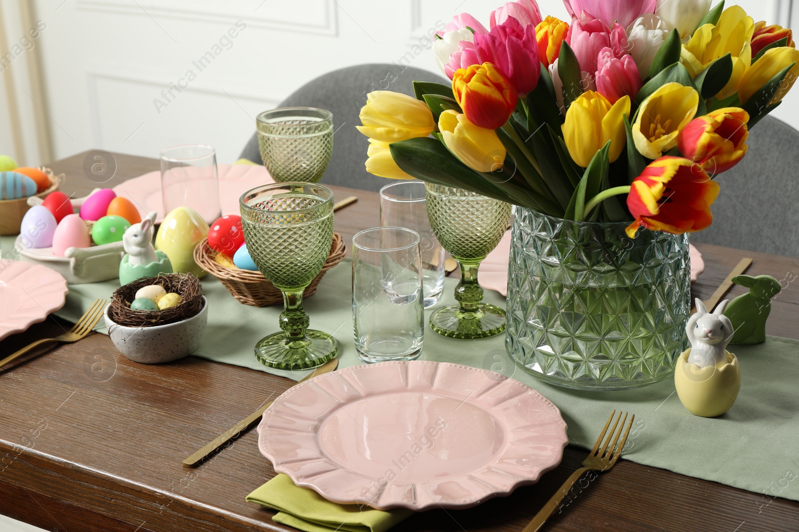 Photo of Easter celebration. Festive table setting with beautiful flowers and painted eggs