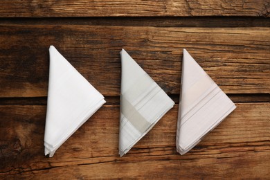 Photo of Different handkerchiefs folded on wooden table, flat lay