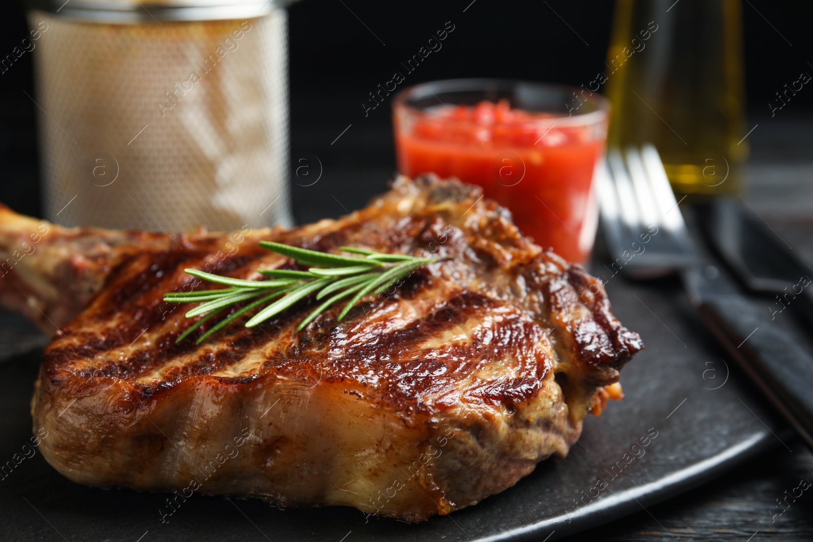 Photo of Tasty grilled beef steak on black table, closeup